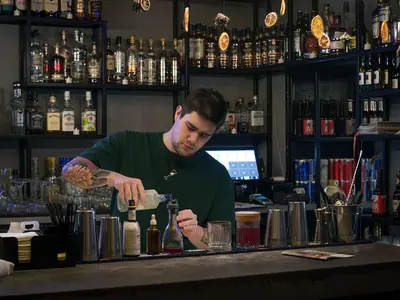 Bartender preparando un trago en la barra de un bar