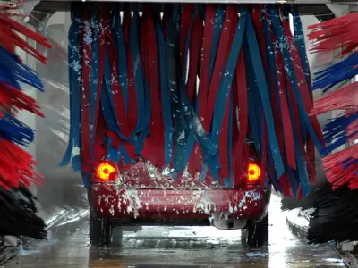 Túnel de lavado automático con rodillos de cepillos sobre un auto