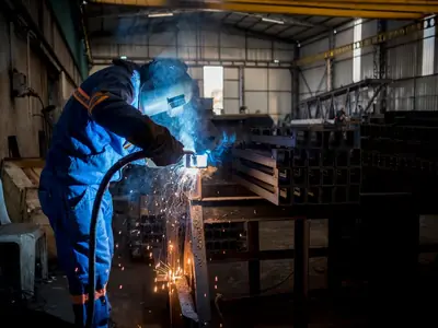 Soldador trabajando en una nave industrial metalúrgica